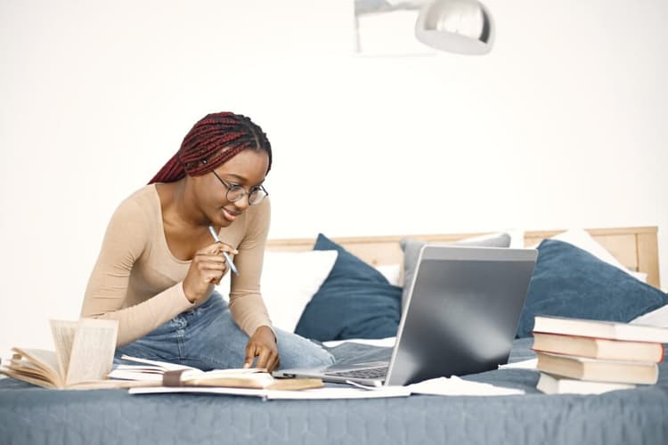 A-student-sitting-in-a-library-focused-on-studying-books-spread-out-on-a-table
